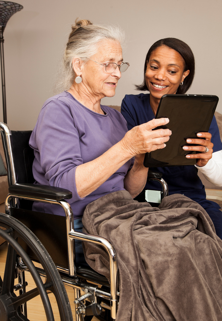 caregiver and elderly on digital tablet